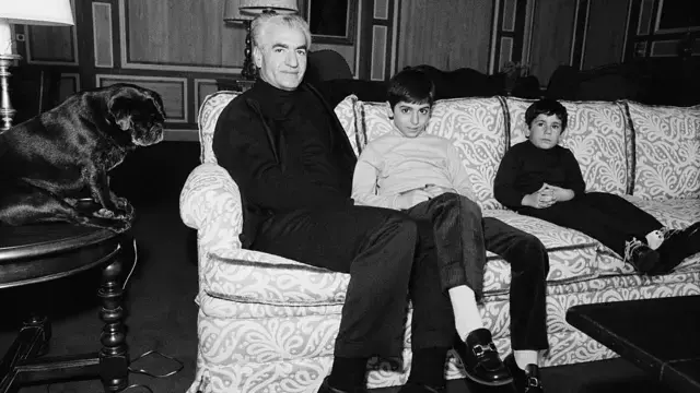 Rıza Pehlevi babası Şah Muhammed Rıza Pehlevi ve kardeşi Ali Rıza Pehlevi'yle birlikte bir koltukta oturuyor